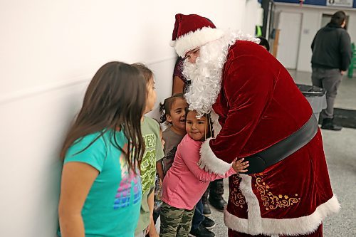 Santa Claus hugs children waiting in line to meet him during the Christmas dinner at the Sioux Valley Dakota Nation Veterans Hall on Thursday evening. (Tim Smith/The Brandon Sun)