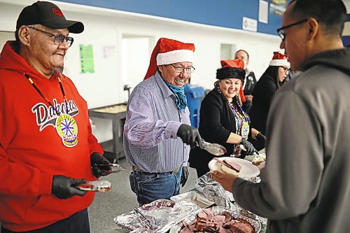22122022
Sioux Valley Dakota Nation council member Anthony Tacan smiles as he serves community members during the annual Christmas Dinner at the SVDN Veterans Hall on Thursday evening. Sioux Valley also held dinners in Winnipeg and Brandon for members of the First Nation in those cities earlier this month and will hold a final dinner today for community elders. This was the first community Christmas Dinner in three years at Sioux Valley as the dinners for 2020 and 2021 were cancelled due to the COVID-19 pandemic.  (Tim Smith/The Brandon Sun)
