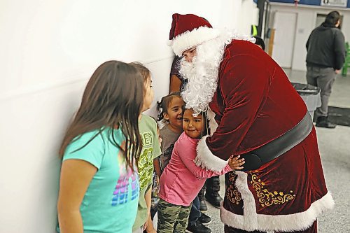 22122022
Santa Claus hugs children waiting in line to meet him during the Christmas Dinner at the Sioux Valley Dakota Nation Veterans Hall on Thursday evening. Sioux Valley also held dinners in Winnipeg and Brandon for members of the First Nation in those cities earlier this month and will hold a final dinner today for community elders. (Tim Smith/The Brandon Sun)