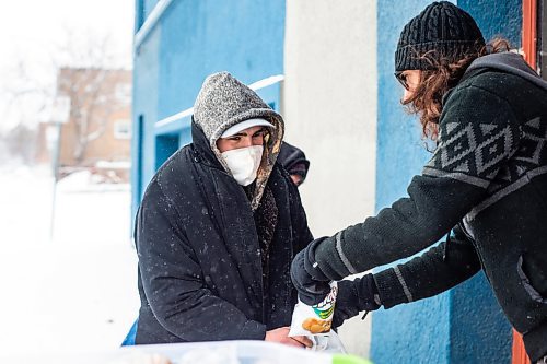 MIKAELA MACKENZIE / WINNIPEG FREE PRESS

Volunteer Curtis McLarty hands out a hot Christmas lunch to Dakota Richard at Agape Table in Winnipeg on Thursday, Dec. 22, 2022.  Standup.
Winnipeg Free Press 2022.