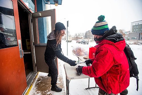 MIKAELA MACKENZIE / WINNIPEG FREE PRESS

Volunteer Curtis McLarty hands out a hot Christmas lunch to Robert Wonder at Agape Table in Winnipeg on Thursday, Dec. 22, 2022.  Standup.
Winnipeg Free Press 2022.