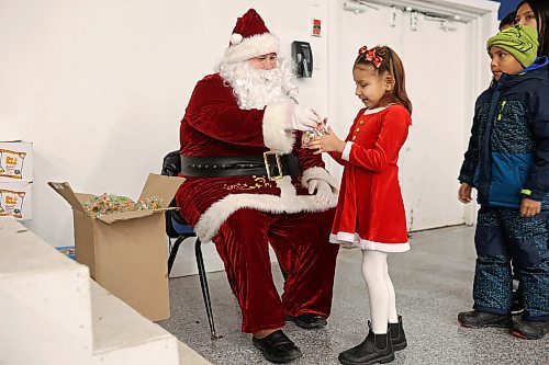 22122022
Jenessa Meeches, seven, meets Santa Claus during the Christmas Dinner at the Sioux Valley Dakota Nation Veterans Hall on Thursday evening. Sioux Valley also held dinners in Winnipeg and Brandon for members of the First Nation in those cities and will hold a final dinner today for community elders. (Tim Smith/The Brandon Sun)