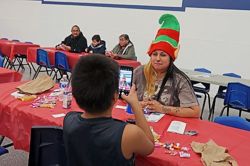22122022
Seven-year-old Ludo Blacksmith takes a photo of his mother Kat Blacksmith during the annual Christmas Dinner at the Sioux Valley Dakota Nation Veterans Hall on Thursday evening. The event included a Christmas dinner, entertainment and a visit by Santa. Sioux Valley also held dinners in Winnipeg and Brandon for members of the First Nation in those cities and will hold a final dinner today for community elders. (Tim Smith/The Brandon Sun)