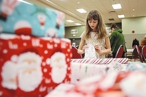 23122022
Ten-year-old Audrey Metruk wraps presents alongside her mom Lindsay (not shown) while helping get everything ready for the Westman and Area Traditional Christmas Dinner at the Keystone Centre. The dinner runs from noon to 6:00 PM on Christmas day. (Tim Smith/The Brandon Sun)
