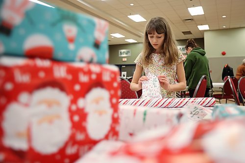 Volunteer Audrey Metruk, 10, wraps presents alongside her mom Lindsay (not shown) while preparing for the Westman and Area Traditional Christmas Dinner at the Keystone Centre on Friday. The dinner runs from noon to 6 p.m. on Christmas Day. (Tim Smith/The Brandon Sun)