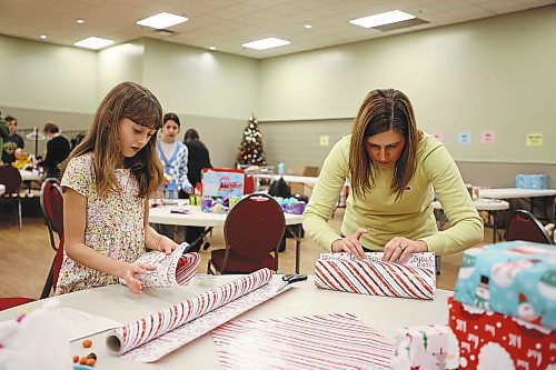 23122022
Ten-year-old Audrey Metruk and her mom Lindsay wrap presents while helping get everything ready for the Westman and Area Traditional Christmas Dinner at the Keystone Centre. The dinner runs from noon to 6:00 PM on Christmas day. (Tim Smith/The Brandon Sun)