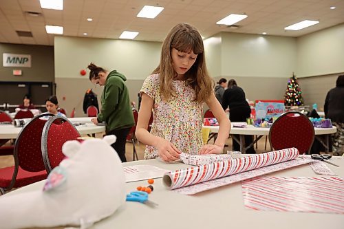 23122022
Ten-year-old Audrey Metruk wraps presents alongside her mom Lindsay (not shown) while helping get everything ready for the Westman and Area Traditional Christmas Dinner at the Keystone Centre. The dinner runs from noon to 6:00 PM on Christmas day. (Tim Smith/The Brandon Sun)