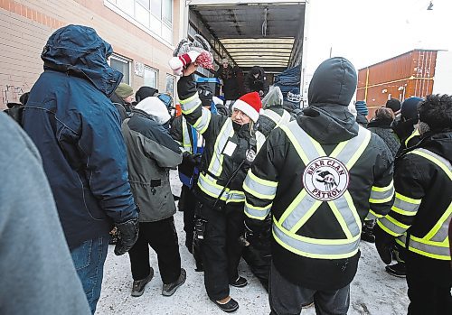 JOHN WOODS / WINNIPEG FREE PRESS
Volunteers with the Bear Clan hand out warm clothing items and lunch to people outside the Salvation Army Sunday, December 25, 2022. The group hit several locations today hoping to reach as many people as possible.

Re: Abas