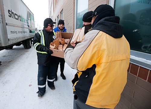 JOHN WOODS / WINNIPEG FREE PRESS
Lorne Proutt, left, Brady Oliveira, centre, and other volunteers with the Bear Clan hand out warm clothing items and lunch to people outside the Salvation Army Sunday, December 25, 2022. The group hit several locations today hoping to reach as many people as possible.

Re: Abas