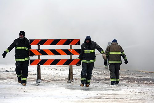 Firefighters move a roadblock into position at the site of the Gladstone Hotel fire on Christmas Day. (Colin Slark/The Brandon Sun)