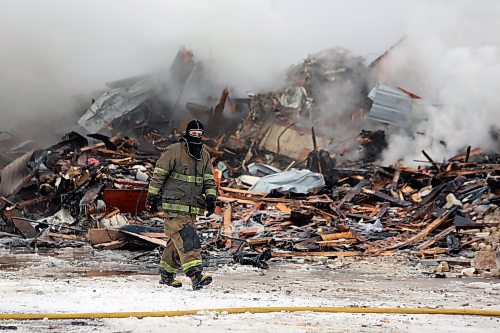 A firefighter in gear walks by the ruins of the Gladstone Hotel on Christmas Day. (Colin Slark/The Brandon Sun)