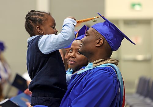 Three year old K'Mor Morgan plays with their father Rurian Morgan's graduation tassle while his mother Natashalee Thompson — who is also graduating — looks at K'Mor during afternoon convocation services at the Brandon University Health Living Centre. (Matt Goerzen/The Brandon Sun)