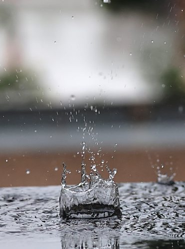 Large drops of water during a summer rainfall bounce off of a metal surface in downtown Brandon, creating splash patterns. (Matt Goerzen/The Brandon Sun)