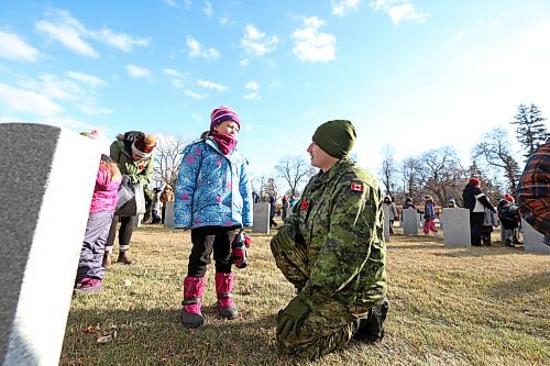 Gunner Robert McHugh with the 1st Regiment, Royal Canadian Horse Artillery, takes a moment to speak with Grade 1 student Baylor Taggart from Valleyview Centennial School about a grave stone for a member of the Canadian Forces following the No Stone Left Alone ceremony at the Brandon Municipal Cemetery. (Matt Goerzen/The Brandon Sun)