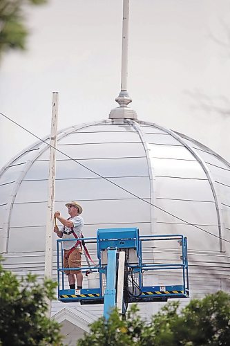 Brandon Sun Bob Desjardin, operations manager for the Provincial Exhibition of Manitoba, preps one of the flag poles atop the Display Building No. II (Dome building) for painting on Tuesday afternoon. (Matt Goerzen/The Brandon Sun)