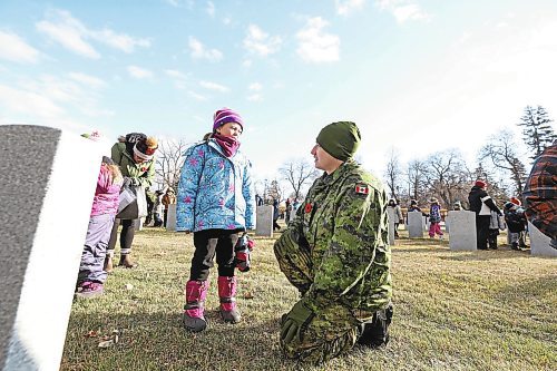 Gunner Robert McHugh with the 1st Regiment, Royal Canadian Horse Artillery, takes a moment to speak with Grade 1 student Baylor Taggart from Valleyview Centennial School about a grave stone for a member of the Canadian Forces following the No Stone Left Alone ceremony on Friday morning at the Brandon Municipal Cemetery. (Matt Goerzen/The Brandon Sun)