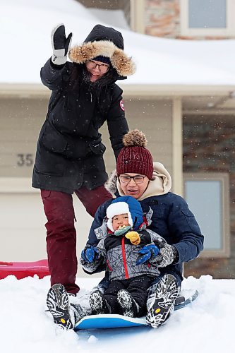 Ethan Liu, almost 2, sleds with his parents Katie Zhang and Louis Liu on a small hill along Sycamore Avenue in Brandon's south end. (Tim Smith/The Brandon Sun)