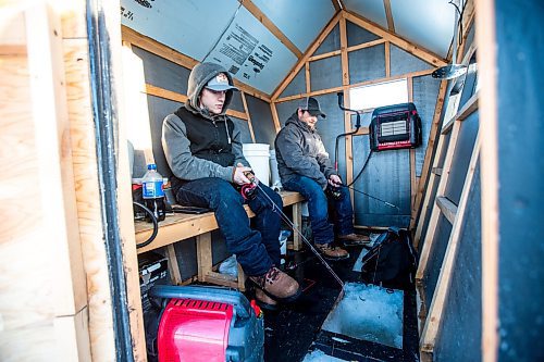 MIKAELA MACKENZIE / WINNIPEG FREE PRESS

Ricky (left) and Isaac Wolf fish at an ice fishing village on the river in Lockport on Friday, Dec. 30, 2022. For Malak story.
Winnipeg Free Press 2022.