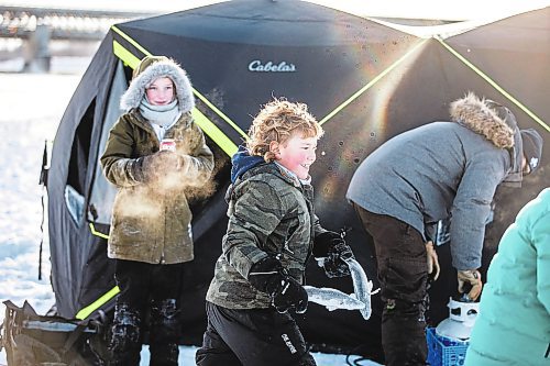 MIKAELA MACKENZIE / WINNIPEG FREE PRESS

Laine Hansen, eight, has a fish fight with a friend using fresh-caught sauger as weapons at an ice fishing village on the river in Lockport on Friday, Dec. 30, 2022. For Malak story.
Winnipeg Free Press 2022.