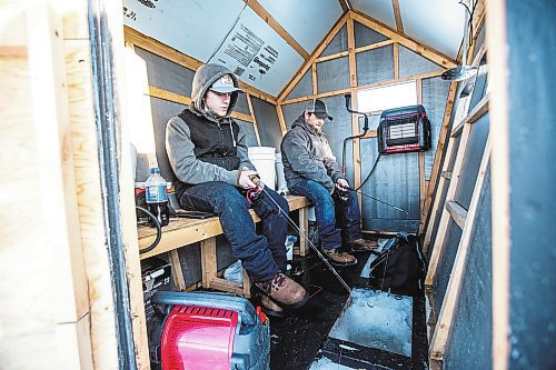 MIKAELA MACKENZIE / WINNIPEG FREE PRESS

Ricky (left) and Isaac Wolf fish at an ice fishing village on the river in Lockport on Friday, Dec. 30, 2022. For Malak story.
Winnipeg Free Press 2022.