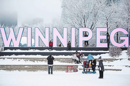 Daniel Crump / Winnipeg Free Press. People gather at the Winnipeg sign at the Forks in Winnipeg on New Year&#x573; Eve. December 31, 2022.