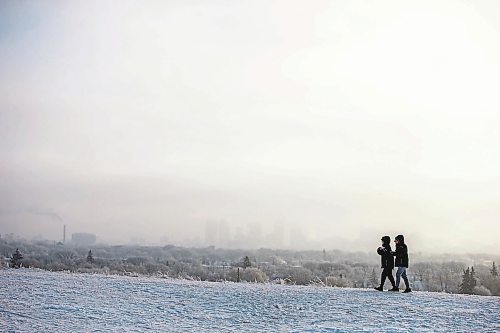 MIKAELA MACKENZIE / WINNIPEG FREE PRESS

Angelica Erasmo (left) and Aaron Musngi watch from Garbage Hill as the sun rises and ice fog hangs over the city in Winnipeg on Tuesday, Jan. 3, 2023. Standup.
Winnipeg Free Press 2022.