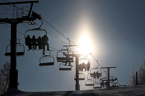 03012023
Skiers and snowboarders are silhouetted by the sun while riding the chair lift at Asessippi Ski Resort on a sunny Tuesday. (Tim Smith/The Brandon Sun)