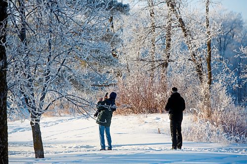 MIKE DEAL / WINNIPEG FREE PRESS
A a couple stop to take photos during a stroll amongst the frost covered trees in Crescent Drive Park Wednesday morning.
230104 - Wednesday, January 04, 2023.