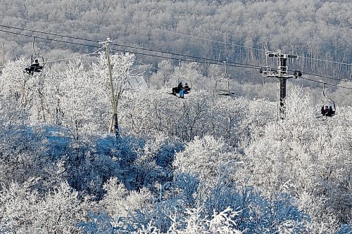 Skiers and snowboarders ride a chairlift, framed by hoar frost, during a day of winter activities at Asessippi Ski Resort earlier this month. (Tim Smith/The Brandon Sun)