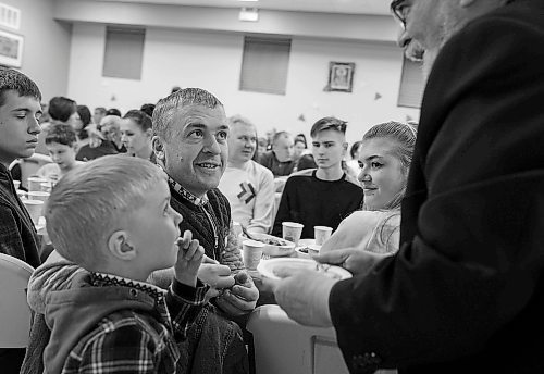 JESSICA LEE / WINNIPEG FREE PRESS

Liubomyr Zelenko (in black) is presented with communion bread. He celebrates Ukrainian Christmas Eve with his family Sviatoslav, 5, and Mariia, 18 (right) on January 6, 2023 at Sts.Vladimir and Olga Cathedral. 200 newcomers gathered at the cathedral.

Reporter: Maggie Macintosh