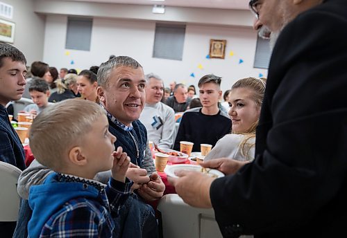 JESSICA LEE / WINNIPEG FREE PRESS

Liubomyr Zelenko (in black) is presented with communion bread. He celebrates Ukrainian Christmas Eve with his family Sviatoslav, 5, and Mariia, 18 (right) on January 6, 2023 at Sts.Vladimir and Olga Cathedral. 200 newcomers gathered at the cathedral.

Reporter: Maggie Macintosh