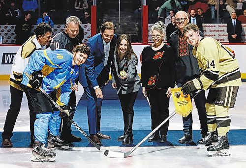 JOHN WOODS / WINNIPEG FREE PRESS
Chief Executive Officer of The Ukrainian Ice Hockey Federation, Aleksandra Slatvytska, centre, drops the opening puck for Ukraine's Vadym Mazur (10) and U of MB Bisons' Geordie Keane (14) before first period action in Winnipeg on Monday, January 9, 2023.