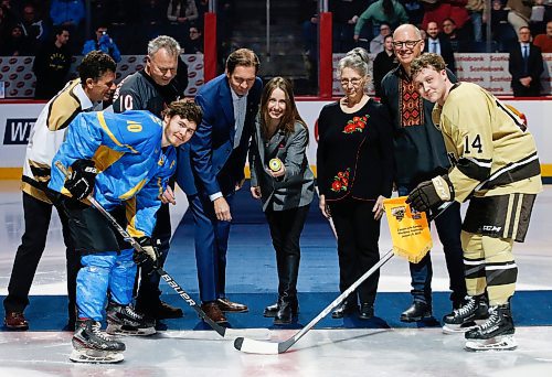 JOHN WOODS / WINNIPEG FREE PRESS
Chief Executive Officer of The Ukrainian Ice Hockey Federation, Aleksandra Slatvytska, centre, drops the opening puck for Ukraine's Vadym Mazur (10) and U of MB Bisons' Geordie Keane (14) before first period action in Winnipeg on Monday, January 9, 2023.