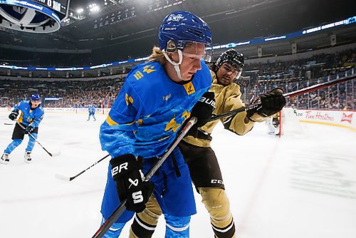 JOHN WOODS / WINNIPEG FREE PRESS
U of MB Bisons' Ryan Gottfried (27) and Ukraine's Artem Grabovetskyi (14) go to the boards for the loose puck during first period action in Winnipeg on Monday, January 9, 2023.