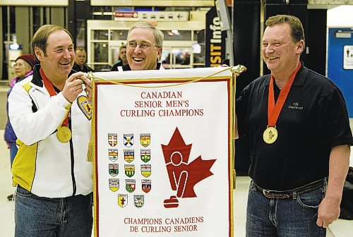 DAVID LIPNOWSKI / WINNIPEG FREE PRESS (March 27, 2011) Senior Men's curling champions (l-r) Peter Prokopowich, Kelly Robertson, and Doug Armour hold their banner at Winnipeg James Armstrong Richardson International Airport Sunday night after defeating the Alberta team in the Canadian senior men&#x2019;s curling championship in Digby, N.S. Saturday afternoon. Bob Scales was missing from his teammates after taking an earlier flight home.