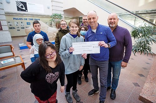 MIKE DEAL / WINNIPEG FREE PRESS
Surrounded by fellow students from Dakota Collegiate, Tatianna, 17, hands Winnipeg Free Press Editor, Paul Samyn and Sports Editor, Jason Bell (right), a cheque for $1350 that will go towards the Miracle on Mountain charity, at the Free Press office Friday morning.
230113 - Friday, January 13, 2023.