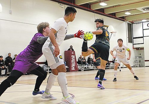 CMU keeper Zach Bartel stretches past Brandon Bobcats Camilo Rodriguez to play the ball while Noah Schindel (6) looks back during their MCAC men's futsal game at ACC on Saturday. Brandon won 7-3. (Thomas Friesen/The Brandon Sun)