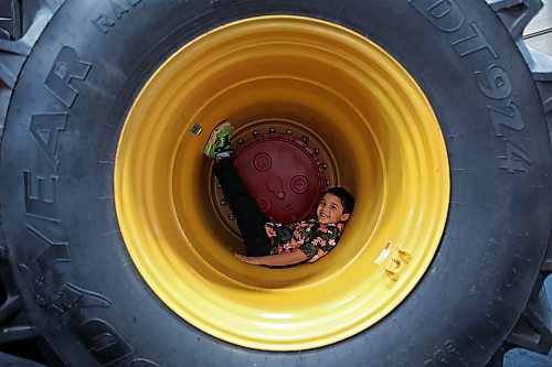 Five-year-old Isaac Jayaranjan sits in the tire well of a Versatile tractor during Manitoba Ag Days at the Keystone Centre on Tuesday. See more coverage inside. (Tim Smith/The Brandon Sun)
