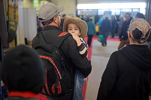 Three-year-old Nathan Friesen looks out from his dad Richard’s shoulder while being carried through exhibits during Manitoba Ag Days at the Keystone Centre on Tuesday. (Tim Smith/The Brandon Sun)