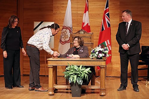 Manitoba Lt.-Gov. Anita Neville (sitting) awards a Queen Elizabeth II Platinum Jubilee medal to Jason Gobeil along with Premier Heather Stefanson (far left) and MLA Len Isleifson (right) at the Brandon University Lorne Watson Recital Hall on Tuesday. Eighty Westman individuals received medals during the ceremony. (Tim Smith/The Brandon Sun)