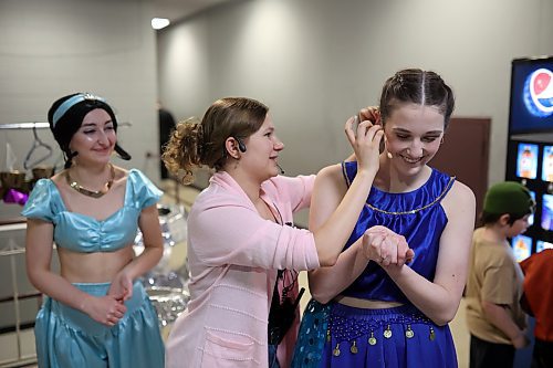 Ava Acevedo helps Amelia Hebert with her mic backstage during the dress rehearsal for DI Productions' presentation of Disney's "Aladdin Jr." at the Western Manitoba Centennial Auditorium on Thursday evening. (Tim Smith/The Brandon Sun)