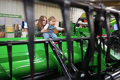 19012023
Eight-year-old Emma Dube checks out a John Deere combine header while held by her mother Sabrina during Manitoba Ag Days 2023 on Thursday.
(Tim Smith/The Brandon Sun)