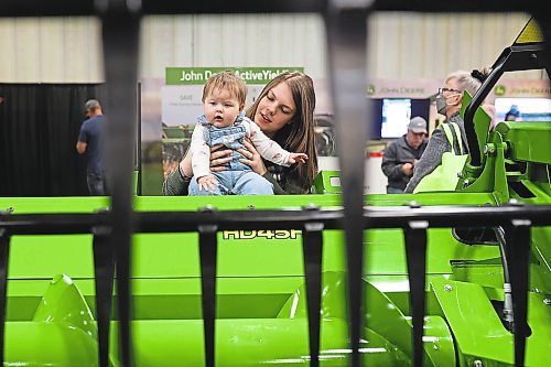 19012023
Eight-year-old Emma Dube checks out a John Deere combine header while held by her mother Sabrina during Manitoba Ag Days 2023 on Thursday.
(Tim Smith/The Brandon Sun)