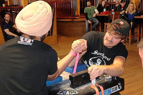 Jaskaran Singh and Herman Janzen get locked in a firm grip during Saturday's Manitoba Arm Wrestling Association tournament, which took place at Houstons Country Roadhouse in Brandon. (Kyle Darbyson/The Brandon Sun)