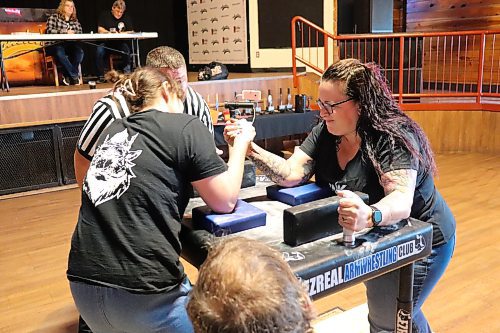 Inked and Oiled Essentials Spa owner Kim Houston, right, tries to get the better of her opponent during an opening contest in Saturday's Manitoba Arm Wrestling Association tournament in Brandon. (Kyle Darbyson/The Brandon Sun)