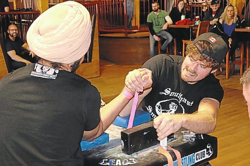 Jaskaran Singh (left) and Herman Janzen get locked in a firm grip during Saturday's Manitoba Arm Wrestling Association tournament, which took place at Houstons Country Roadhouse in Brandon. (Kyle Darbyson/The Brandon Sun)