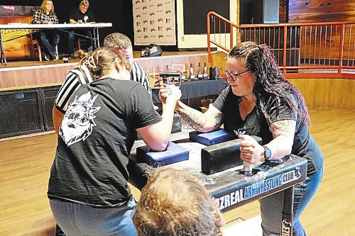 Inked and Oiled Essentials Spa owner Kim Houston (right) tries to get the better of her opponent during an opening contest in Saturday's Manitoba Arm Wrestling Association tournament in Brandon. (Kyle Darbyson/The Brandon Sun)