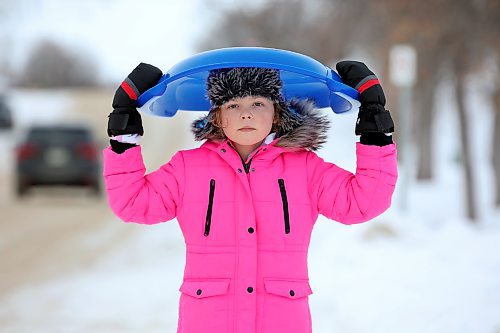 Isabella Jones, 8, carries her sled as she walks to Rideau Park to go sledding Monday afternoon. (Tim Smith/The Brandon Sun)