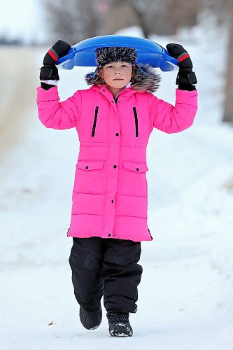 23012023
Eight-year-old Isabella Jones carries her sled over her head while walking to Rideau Park to go sledding on a mild Monday afternoon. 
(Tim Smith/The Brandon Sun)