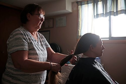 23012023
Iris Karton braids her daughter Meigan Oakley's hair in preparation to cut it in Oakley's basement hair studio on Monday afternoon. Oakley has been growing her hair for 10 years and will donate the cut hair to Wigs For Kids. She also donated her hair to the same organization a decade ago. (Tim Smith/The Brandon Sun)